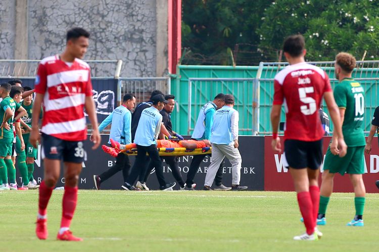 Penjaga gawang Persebaya Surabaya Andhika Ramadhani ditandu karena cedera, berbenturan dengan pemain Madura United Francisco Rivera saat laga pekan ke-12 BRI liga 1 2023-2024 yang berakhir dengan skor 3-0 di Stadion Gelora Bangkalan, Minggu (17/9/2023) sore.