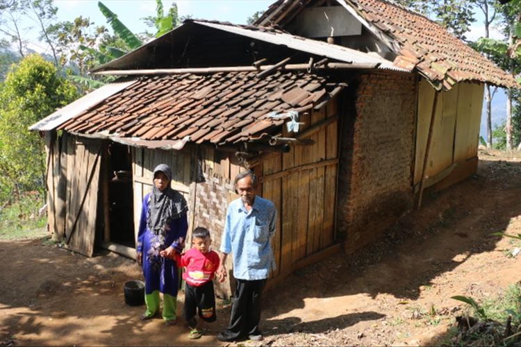 Sati (60), Jodi (7), dan Rakun (70) berdiri di sekitar rumahnya, di dusun pahing RT 1 RW 3, Desa Margabakti Kecamatan Kadugede Kabupaten Kuningan Jawa Barat, Senin (29/7/2019). 