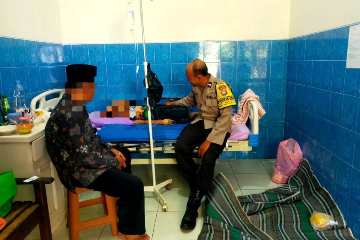 Polisi melihat kondisi salah satu korban dugaan keracunan massal di sebuah klinik kesehatan di Kecamatan Wonotirto, Kabupaten Blitar, Minggu (11/5/2025)