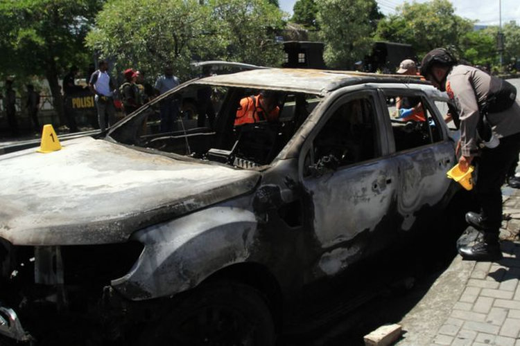 Polisi melihat kondisi mobil yang dibakar massa di Sentani, Kabupaten Jayapura, Papua, Kamis (28/12/2023)