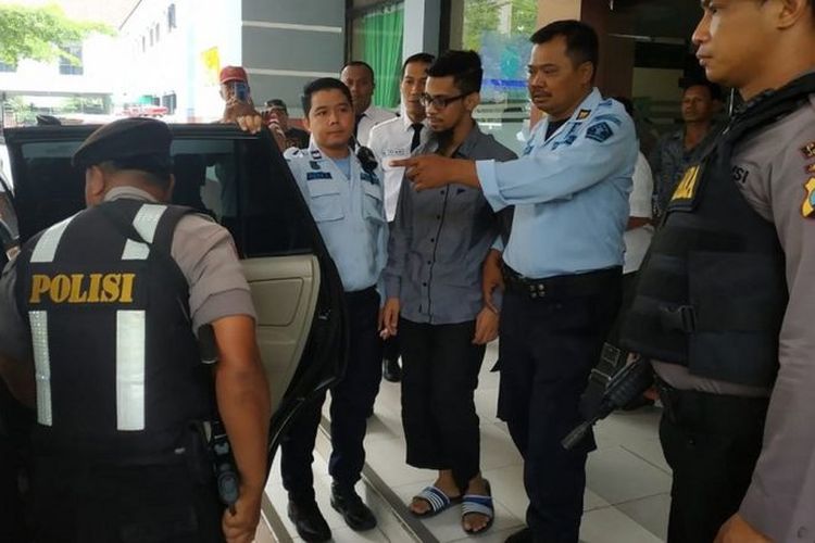 Wildan Bahriza (tengah, berkacamata) bersama petugas lembaga pemasyarakatan dan anggota polisi.