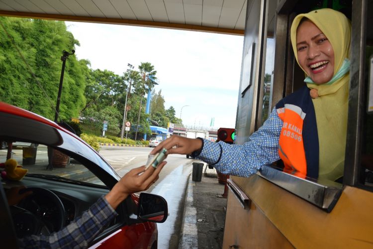 Petugas gardu Jasa Marga sedang melayani pengemudi untuk membayar tol. Pembayaran non-tunai di Gerbang Tol Jakarta-Cikampek, mulai terapkan secara bertahap. Jasa Marga memastikan, para pengguna jalan yang tidak memiliki saldo yang cukup, bisa melakukan pengisian ulang di gardu petugas gerbang tol.