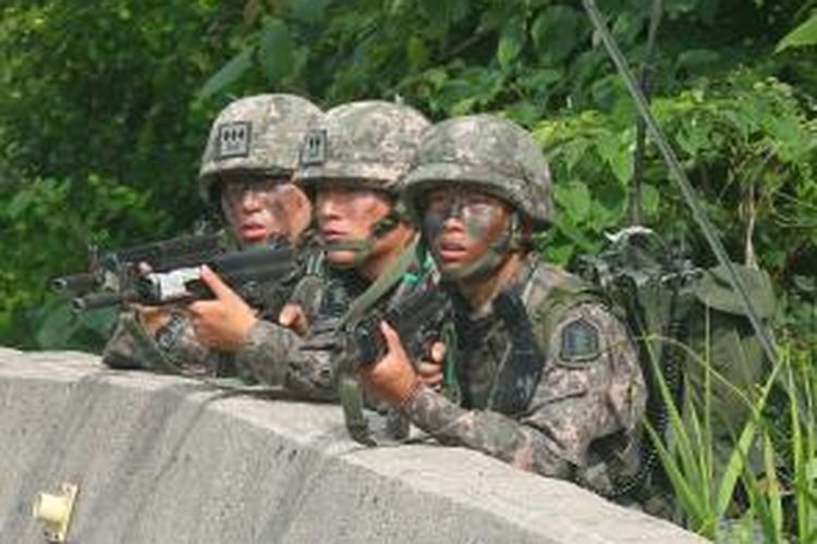 Para prajurit Korea Selatan ini berlindung di balik pembatas jalan saat mengepung tersangka pelaku penembakan lima tentara di sebuah kawasan hutan di wilayah timur negeri itu. Setelah dikepung selama 24 jam, pelaku penembakan bisa diringkus.