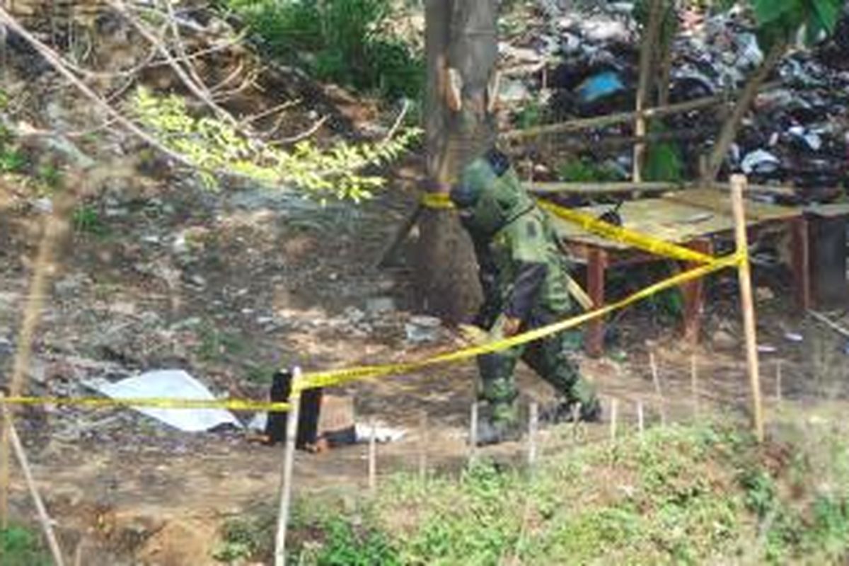 Petugs gegana Polda Metro Jaya memeriksa benda di Kali Buara  yang diduga sebagai bahan peledak. Senin (2/6/2014).