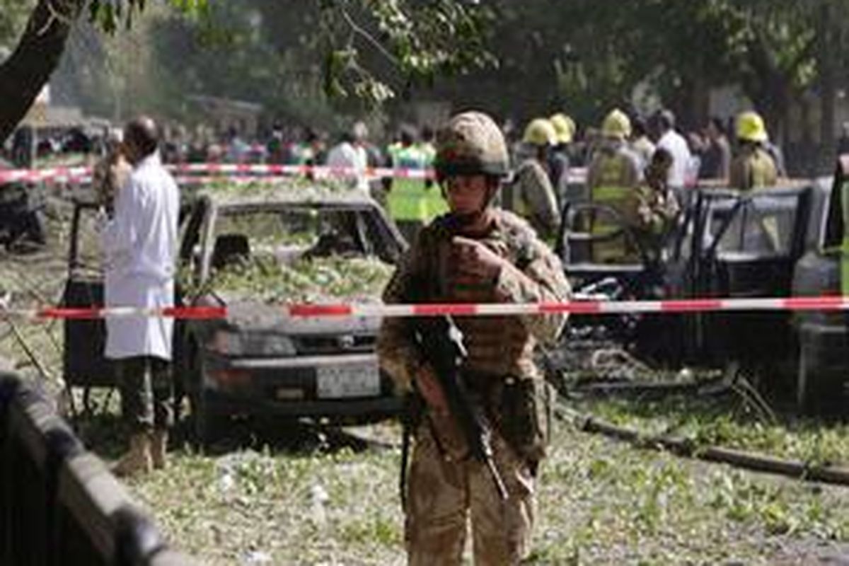 Seorang tentara NATO berjaga di lokasi ledakan bom bunuh diri dekat pintu utama markas NATO di Kabul, Afganistan, 15 Agustus 2009.