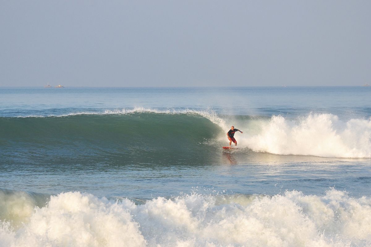Seorang peselancar sedang menunggangi ombak di Pantai Cimaja, Sukabumi, Jawa Barat. 