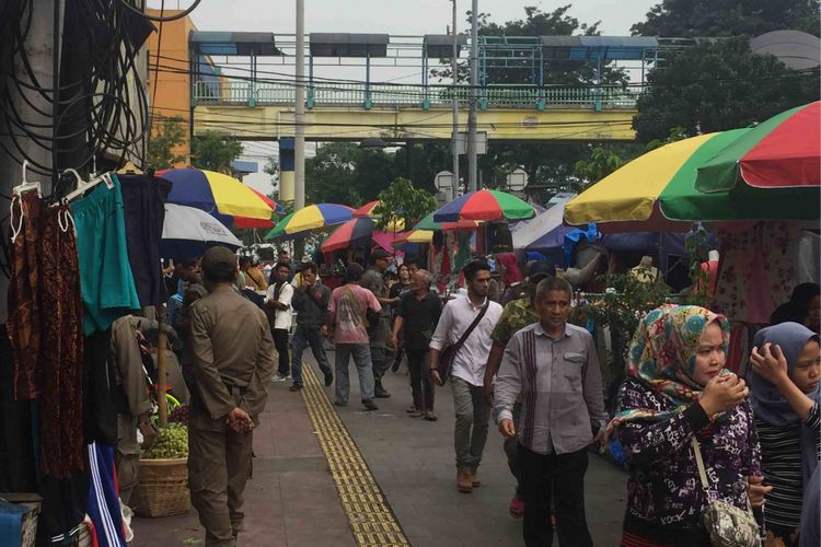 Puluhan pedagang kaki lima (PKL) mengokupansi trotoar di sepanjang Gedung Blok F Tanah Abang hingga menuju ke simpang Jalan Jatibaru Raya, Jakarta Pusat. Pantauan Kompas.com di lokasi, pukul 11.00 Jumat (25/5/2018), puluhan PKL tampak santai menjajakan barang dagangannya dimulai dari simpang Jalan Jatibaru Raya.