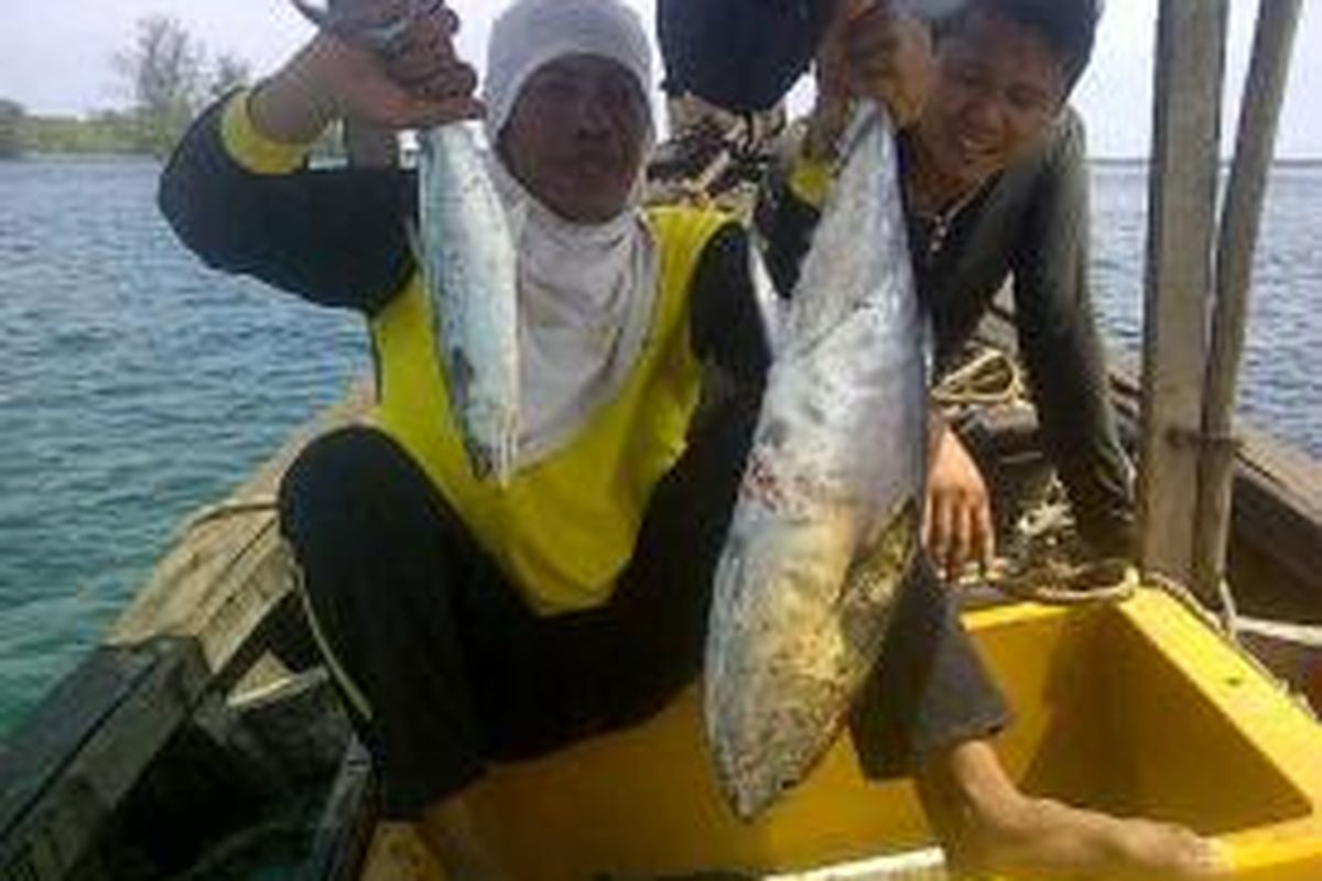 Pemancing memamerkan hasil tangkapan tuna dan tenggiri