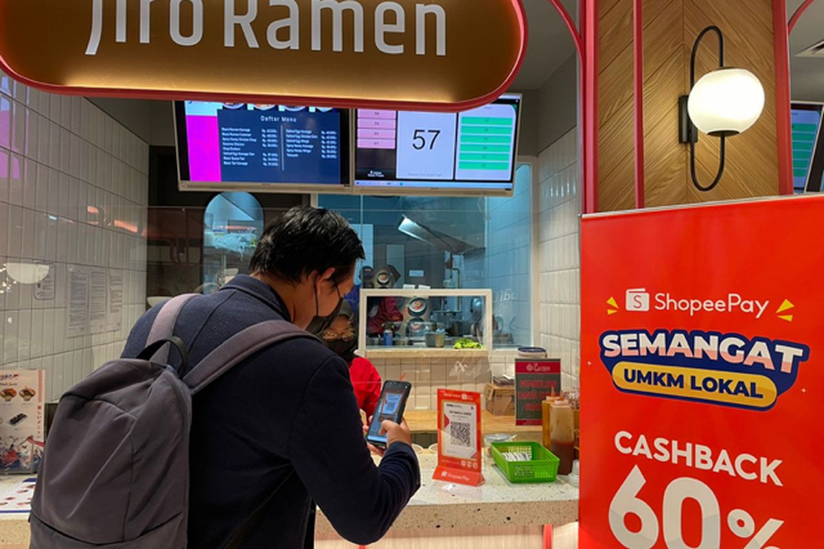 Seorang pengunjung sedang melakukan transaksi menggunakan ShopeePay sembari menikmati promo cashback 60% di sentra UMKM Le Garden
