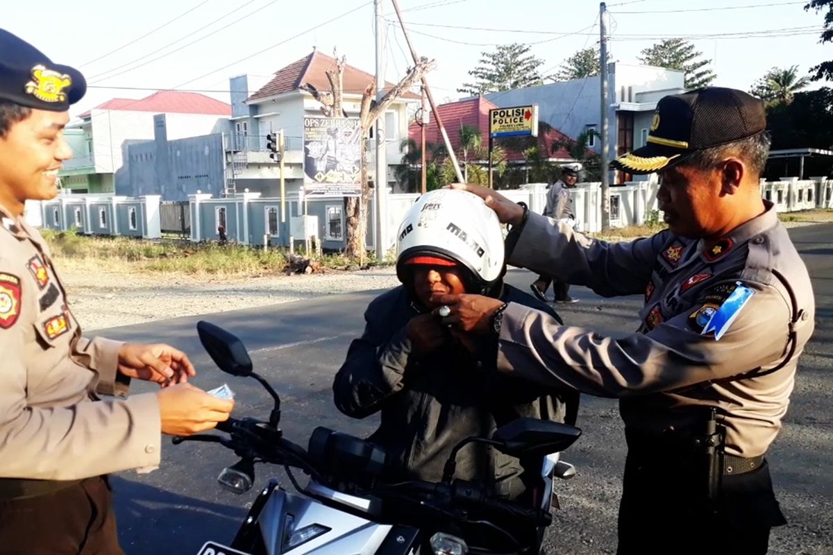 Seorang pengendara roda dua mengenakan helm terbalik saat operasi Zebra 2019 di gelar di jalan Trans Sulawesi, Kecamatan Belopa, Kabupaten Luwu, Kamis (24/10/2019).