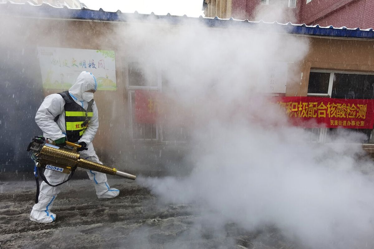 A volunteer disinfects the area as it snows during the Covid-19 lockdown in Changchun in northeast China's Jilin province Saturday, March 12, 2022. China on Friday ordered the lockdown of the 9 million residents of the northeastern city of Changchun amid a new spike in Covid-19 cases in the area attributed to the highly contagious omicron variant. (Chinatopix Via AP)