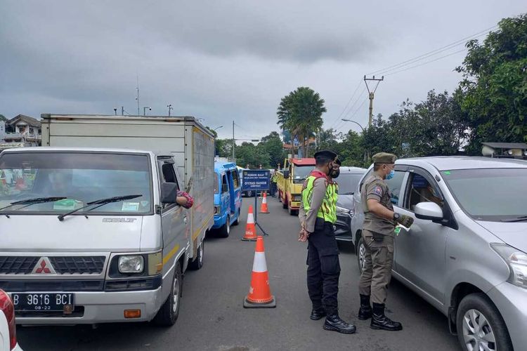 Sejumlah petugas gabungan nampak memutarbalikkan kendaraan yang tidak membawa bukti surat rapid antigen di Simpang Gadog, Puncak Bogor, Jawa Barat, Kamis (11/3/2021).