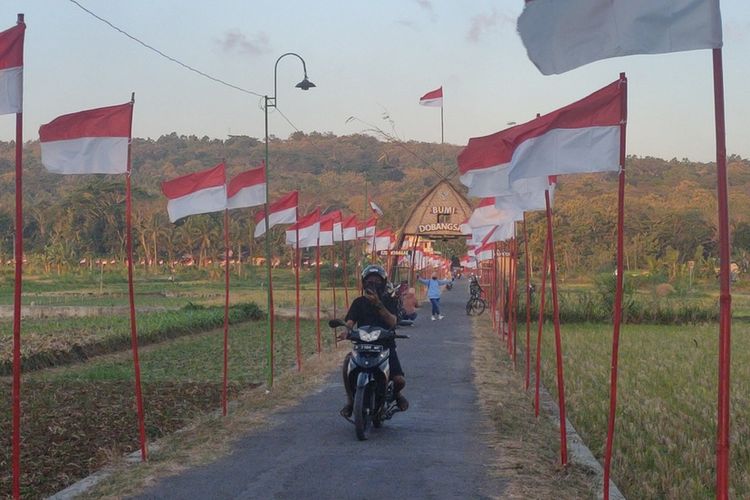 Ribuan bendera Merah Putih berkibar di jalan yang membelah area sawah Pedukuhan Dobangsan, Kalurahan Giripeni, Kapanewon Wates, Kabupaten Kulon Progo, Daerah Istimewa Yogyakarta. Warga mayoritas petani selalu menyambut peringatan kemerdekaan RI dengan mengibarkan bendera seperti ini selama satu bulan penuh