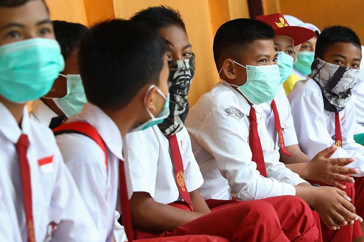 Siswa sekolah dasar di Natuna, Kepulauan Riau, mengenakan masker saat berada di area sekolah mereka, Selasa (4/2/2020). Hampir seluruh warga di Natuna menggunakan masker menyusul keputusan Pemerintah RI untuk menempatkan WNI yang dievakuasi dari Wuhan, China, di pulau tersebut.