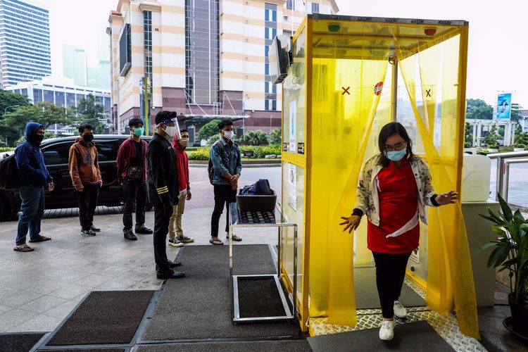 Pekerja memasuki bilik disinfektan sebelum memasuki pusat perbelanjaan Senayan City, Jakarta Pusat, Selasa (9/6/2020). Untuk mendukung kelancaran masa transisi dan mencegah penularan Covid-19, pengelola mal menyediakan hand sanitizer otomatis di beberapa titik mal, pengecekan suhu tubuh di pintu-pintu masuk, dan juga menggalakkan physical distancing kepada para pengunjung.