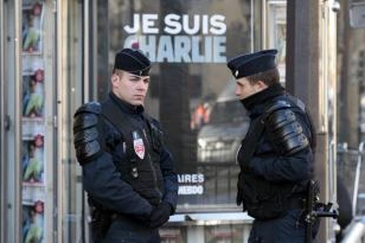 Anggota kepolisian Perancis berjaga di salah satu sudut kota Paris di dekat tulisan Je Suis Charlie (Kami adalah Charlie). Pemerintah Perancis mengerahkan ribuan personel keamanan untuk menjaga lokasi-lokasi yang dianggap sensitif pasca-serangan teror yang menewaskan 17 orang pekan lalu.