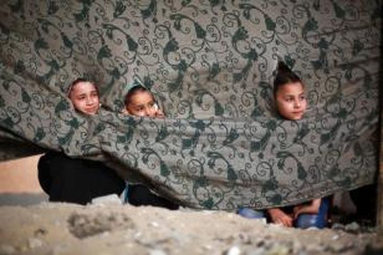 Anak-anak wanita Palestina menonton teman laki-laki mereka ambil bagian dalam kegiatan liburan musim panas bergaya militer yang diadakan oleh Hamas Kota Gaza, 10 Juni 2013.