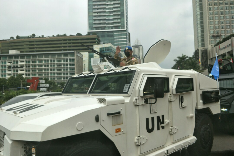 Seorang prajurit TNI melambaikan tangan ke arah warga saat parade alutsista di Jalan Sudirman-Thamrin, Jakarta Pusat, dalam rangka HUT ke-77 TNI, Rabu (5/10/2022).