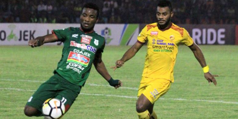 Pemain PSMS Medan, Wilfried Yessoh dan pemain Sriwijaya FC, Marckho Sandy berduel dalam laga pekan ke-9 Liga 1 musim 2018 du Stadion Teladan, Medan, Jumat (18/5/2018).
