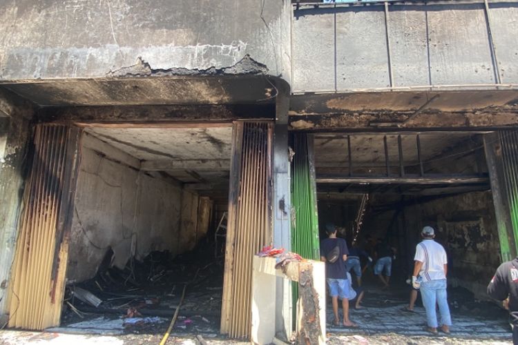 Pedagang Pasar Krian Lama mengais barangnya yang terbakar, Selasa (20/8/2024).