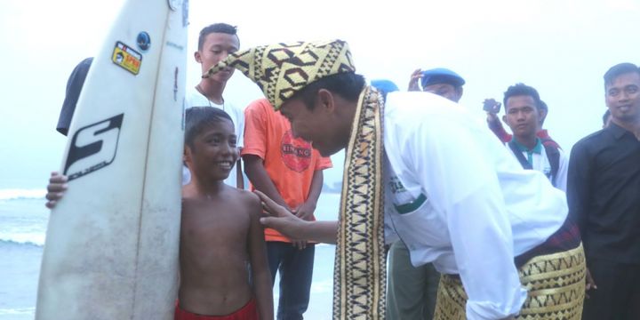 Menteri Pemuda dan Olahraga Imam Nahrawi saat menemui salah satu peselancar cilik di Pantai Labuham Jukung, Krui, Kabupaten Pesisir Barat, Lampung, Jumat (13/4/2018).