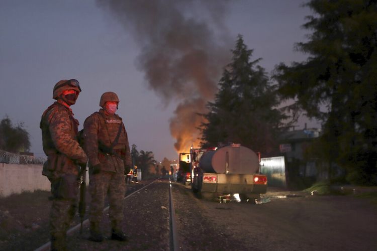 Tentara berjaga di dekat lokasi kebocoran gas yang terbakar setelah serangkaian ledakan di sebuah lingkungan di Puebla, Meksiko, Minggu, 31 Oktober 2021. 
