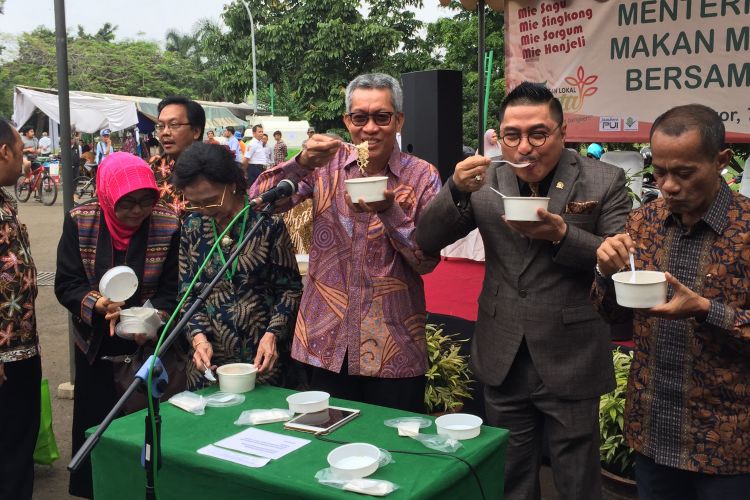 Kepala Badan Penelitian dan Pengembangan Pertanian (Balitbangtan) Kementerian Pertanian (Kementan) Muhammad Syakir (ketiga dari kanan) mencoba mie berbahan Sorghum di acara Pangan Lokal Fiesta, kampus penetlitan pertanian Cimanggu, Bogor Rabu (7/11/2018)