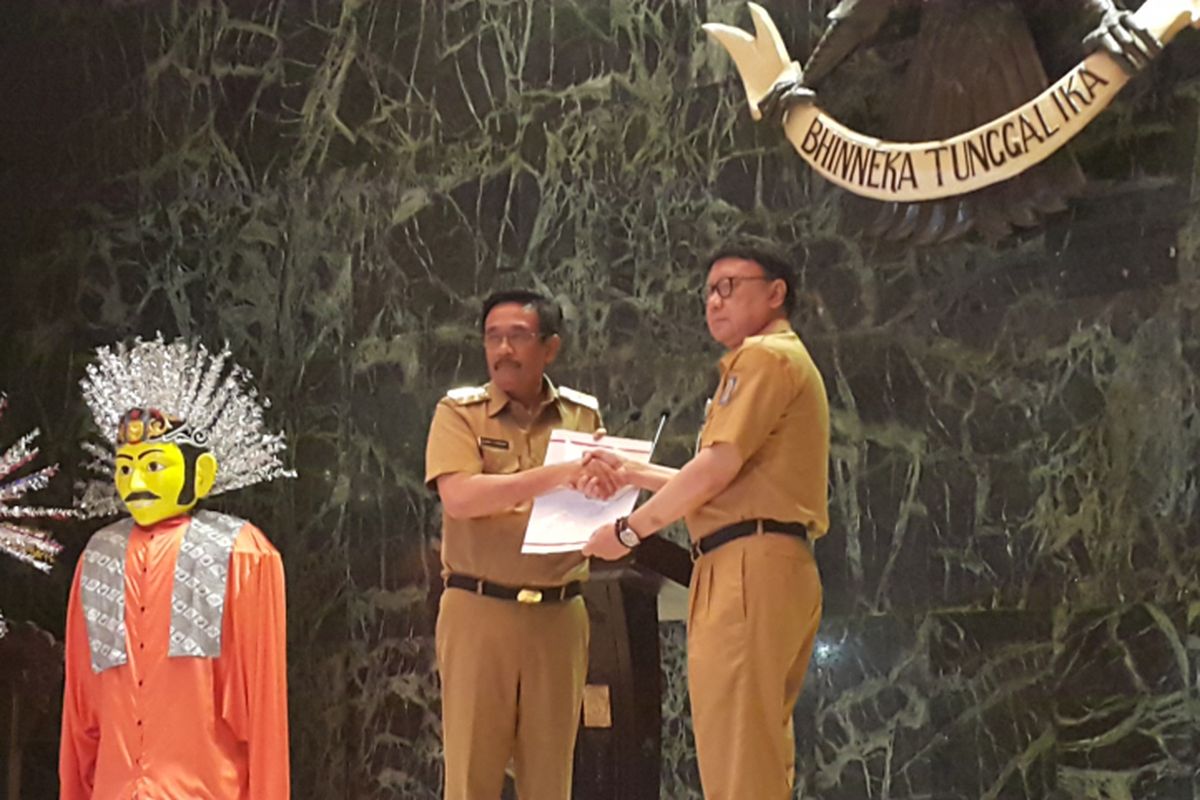 Menteri Dalam Negeri Tjahjo Kumolo (kiri) memberikan surat Keputusan Presiden tentang penunjukkan Pelaksana Tugas (Plt) Gubernur DKI Jakarta kepada Wakil Gubernur DKI Jakarta Djarot Saiful Hidayat (kanan) di Balai Agung, Balai Kota DKI Jakarta, Jalan Medan Merdeka Selatan, Selasa (9/5/2017).