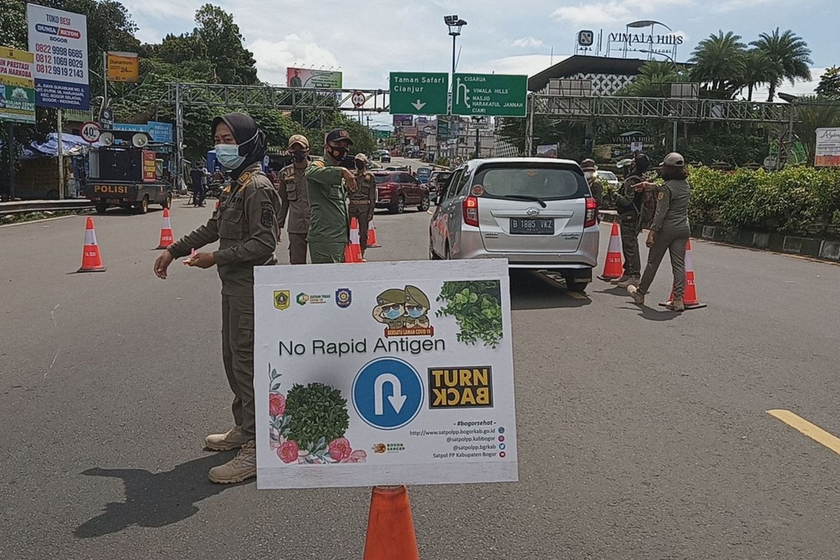 Sejumlah petugas sedang memeriksa surat rapid antigen sebagai syarat untuk ke Puncak Bogor di Simpang Gadog, Kabupaten Bogor, Jawa Barat, Jumat (12/2/2021)