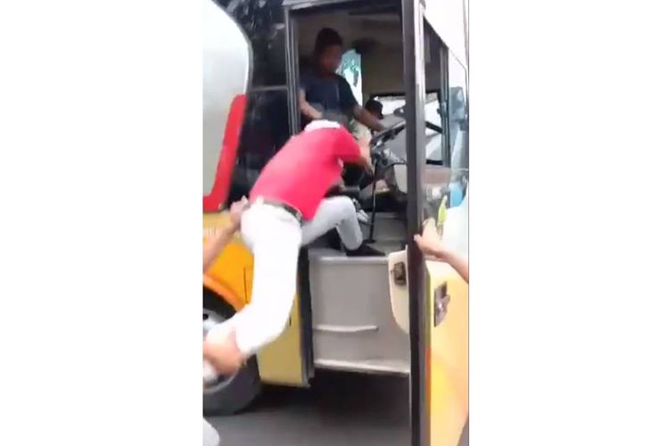 Tangkapan layar video yang menampilkan driver bus Dali Mas yang dikejar massa usai ngeblong atau melawan arus di jalan Lamongan, Jawa Timur.