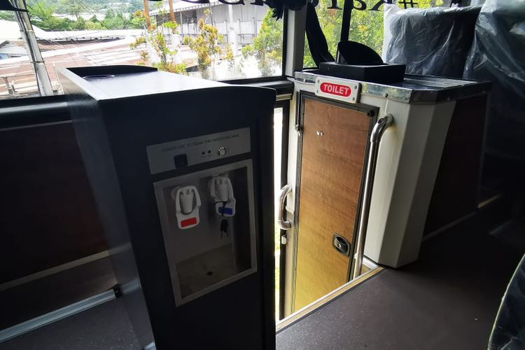 Dispenser dan toilet tengah di kabin bus