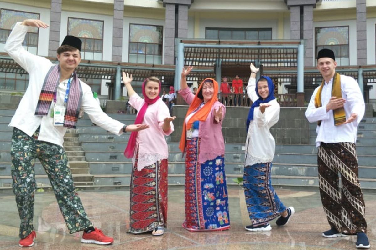 Atlet dan pelatih Asian Games asal Uzbekistan berfoto memakai baju adat Betawi saat berkunjung ke PBB Setu Babakan, Jakarta Selatan, Minggu (26/8/2018).