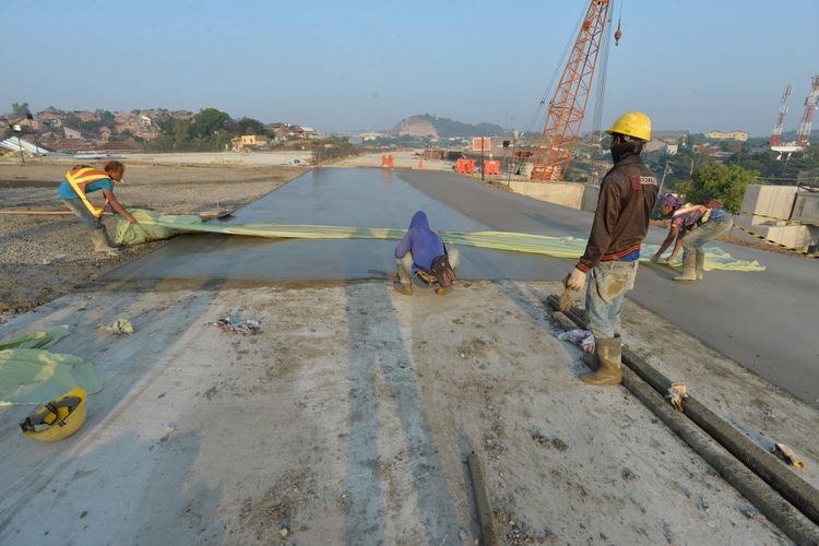 Pekerja mengerjakan pengecoran lapisan beton proyek Jalan Tol Batang-Semarang di kawasan Simpang Susun Krapyak, Semarang, Jawa Tengah, Jumat (1/6). PT Jasa Marga (Persero) Tbk. menyatakan, Proyek Jalan Tol Batang-Semarang dapat menjadi jalur fungsional untuk arus mudik dan balik Lebaran 2018 mulai dari ruas Batang hingga ruas Krapyak. ANTARA FOTO/Widodo S Jusuf/kye/18.