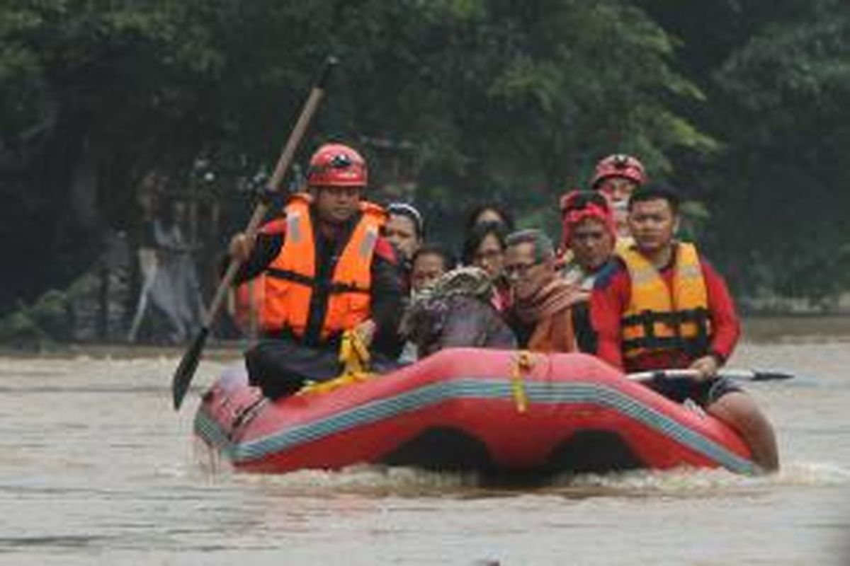 Warga korban banjir di Kampung Pulo, Jatinegara, Jakarta Timur, dievakuasi menggunakan perahu karet ke tempat pengungsian, Senin (13/1/2014). Sejumlah wilayah di Jakarta terendam banjir akibat curah hujan yang tinggi dan air kiriman dari Bogor. TRIBUNNEWS/HERUDIN