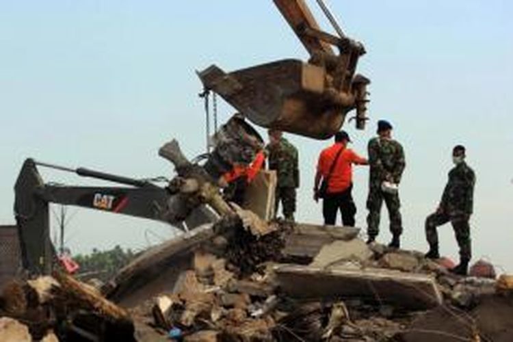 Anggota TNI membersihkan puing pesawat Hercules C-130 milik TNI AU yang  jatuh di Jalan Jamin Ginting, Medan, Rabu (01/07/2015). Pesawat jatuh pada Selasa, dua menit setelah lepas landas dari Pangkalan Udara Soewondo pukul 12.08 ketika hendak menuju Tanjung Pinang.