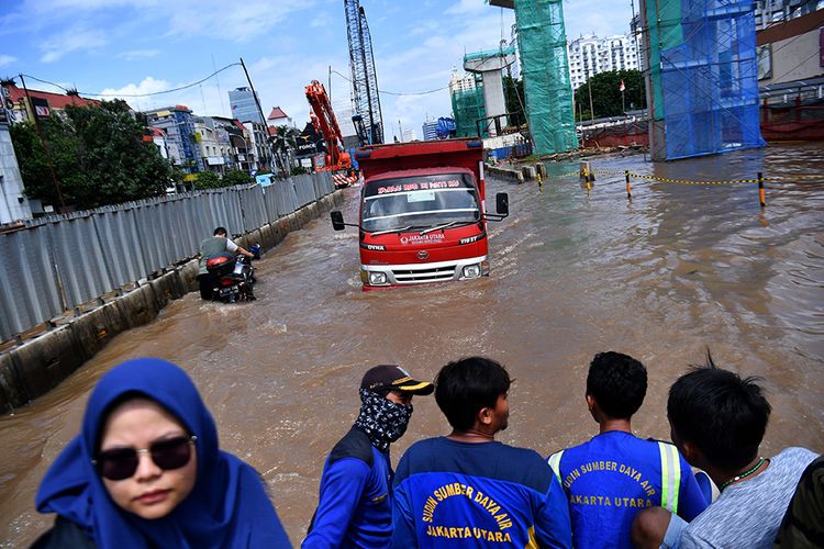 Truk melintasi banjir yang menggenangi Jalan Boulevard Barat Raya, Kelapa Gading, Jakarta Utara, Minggu (23/2/2020). Hujan deras sejak Minggu 23 Februari dini hari membuat sejumlah daerah di Ibu Kota tergenang banjir.