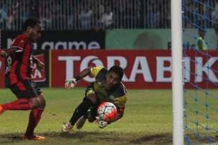 Aksi penyerang mungil Persipura, Lukas Mandowen jelang membobol gawang Persela yang dikawal kiper Choirul Huda (kuning) di Stadion Surajaya, Lamongan, Senin (23/5/2016).
