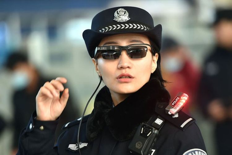 Seorang polisi mengenakan kacamata yang mempunyai teknologi untuk mengenali para pelaku kejahatan di Zhengzhou Timur, China.