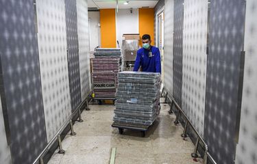 Pegawai mendorong troli berisi uang tunai pecahan Rp 100 ribu dan Rp 50 ribu yang akan dikirimkan ke kantor cabang di Sentra Kas Bank Mandiri, Jakarta, Rabu (6/4/2022).  Bank Mandiri akan menyediakan pelayanan bagi para nasabah yang ingin melakukan kegiatan perbankan pada periode libur lebaran 2023.