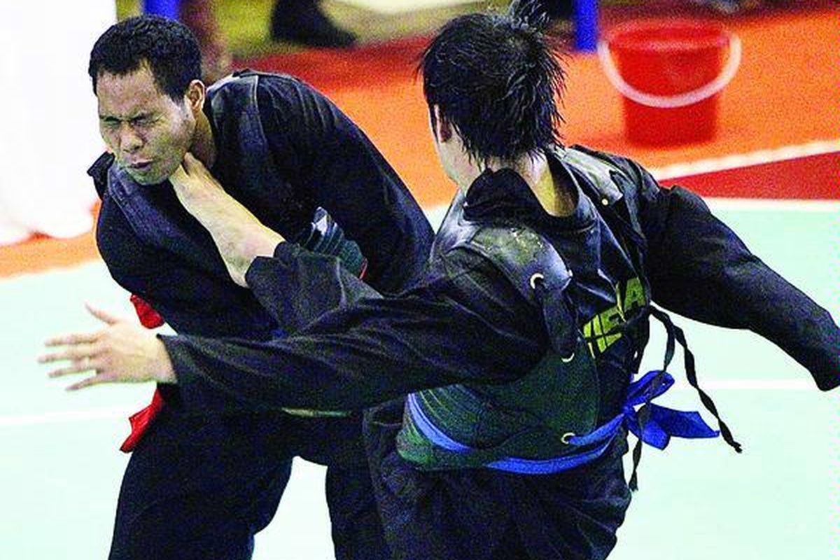 Pesilat Indonesia, Heriono (kiri), terkena tendangan pesilat Vietnam, Le Dang Minh dalam laga kelas I (85 - 90 kg) kategori tanding putra Kejuaraan Dunia Pencak Silat XIII 2010 di Padepokan Pencak Silat, Jakarta, Rabu (15/12). Heriono kalah angka, 56-88.