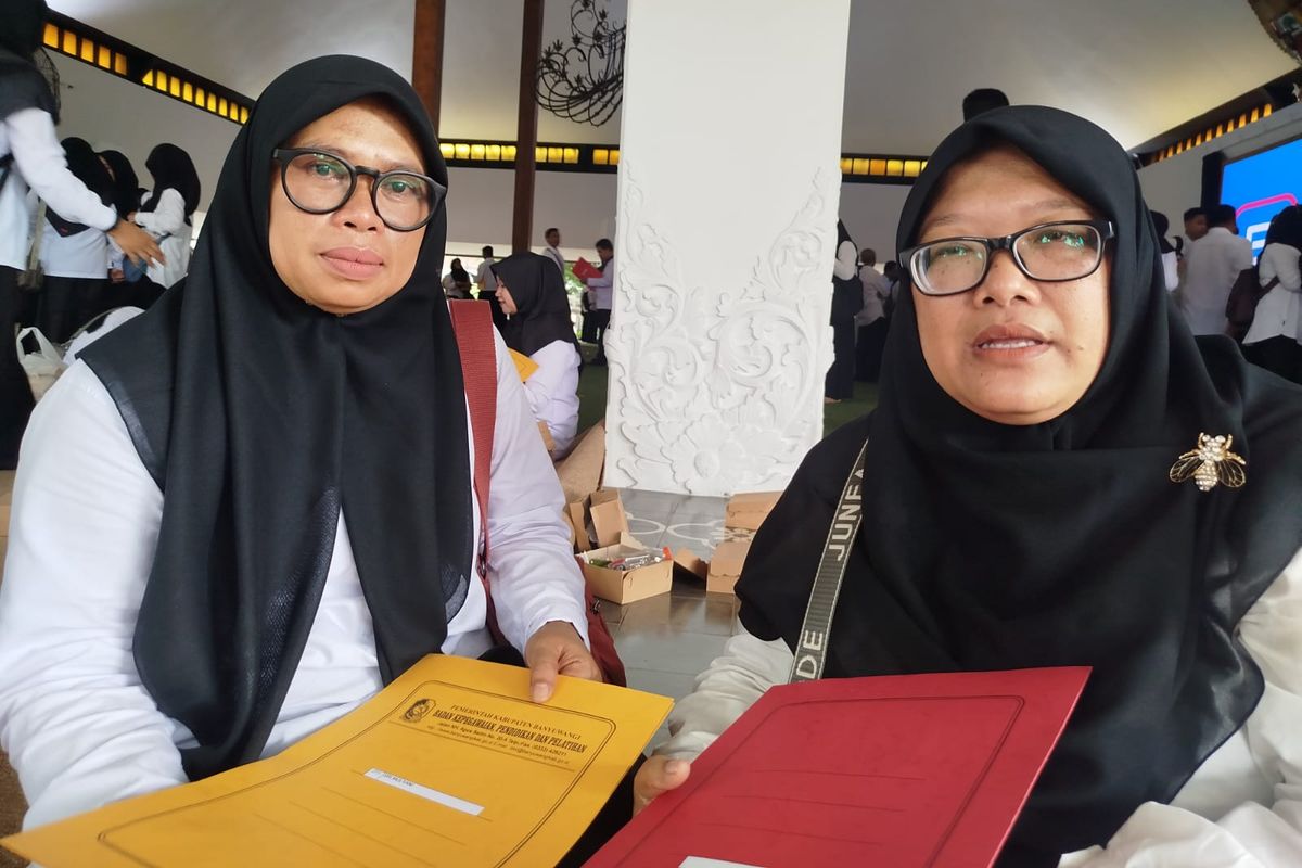 Sri Mulyani (pegang map kuning) menangis terharu usai menerima SK pengangkatan PPPK di Pendopo Sabha Swagata Blambangan, Jumat (23/5/2025)