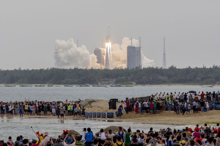 Peluncuran roket China Long March 5B dari Wenchang Space Launch Center, Provinsi Hainan, disaksikan orang-orang pada 29 April 2021. Roket China jatuh tak terkendali ke Bumi pada Sabtu (30/7/2022) dan memicu teguran dari Amerika Serikat.