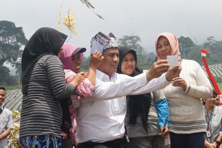 Menteri Pertanian Andi Amran Sulaiman saat selfie bersama dengan beberapa petani bawang putih saat panen perdana bawang putih di desa Tamansari Kecamatan Licin Banyuwangi Jumat (23/3/2018) 