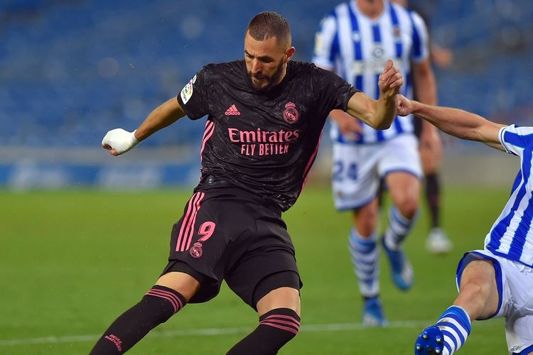 Penyerang Real Madrid, Karim Benzema, tengah berduel dengan bek Real Sociedad, Aritz Elustondo, pada pekan kedua Liga Spanyol, Senin (21/9/2020) dini hari WIB.