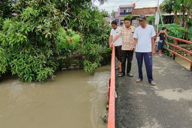 Kepala Desa Jatipura Kecamatan Susukan Kabupaten Cirebon Jawa Barat, Rio Budiarto (tengah) menunjukan titik lokasi penemuan bungkusan kain berisi mayat perempuan di sungai Wangan Ayam, pada Jumat (19/1/2024). Rio menyebut mayat dalam perempuan mulai terungkap setelah proses penanganan dan laporan kehilangan orang tua korban.