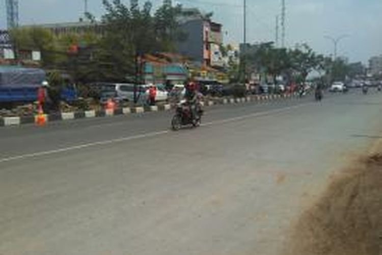 Beberapa petugas sedang menata ulang jalur hijau di median jalan Margonda, Depok, Sabtu (25/10/2014).