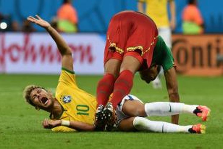 Penyerang Brasil Neymar bereaksi kesakitan setelah tackle yang dilakukan gelandang Kamerun Joel Matip dalam laga Grup A Piala Dunia di Mane Garrincha National Stadium di Brasilia, Selasa (24/6/2014). Brasil menang 4-1. 