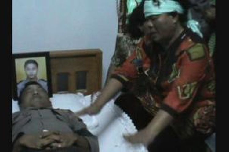 Jenazah Brigadir Benny Sihombing saat di rumah duka yang ditangisi sang ibunda, Berliana br Siregar di  rumah duka di Jalan Haji Ir Juanda, Binjai, Sumatera Utara, Jumat (21/11/2014).