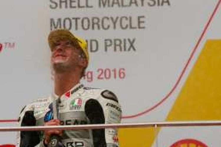 Pebalap Moto3 dari tim Aspar Mahindra Team, Francesco Bagnaia (Italia), menyemprotkan sampanye untuk merayakan kemenangannya pada balapan GP Malaysia di Sirkuit Sepang, Minggu (30/10/2016).