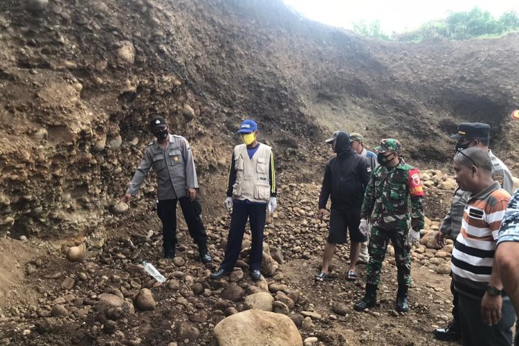 Petugas memeriksa lokasi longsor yang menewaskan Suhan, pekerja tambang. 